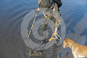 Treasure hunter is looking for a metal detector in the river