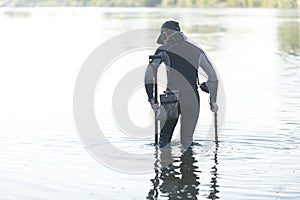 Treasure hunter is looking for a metal detector in the river