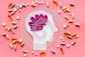 Treat brain diseases. Head with plastiline meanders and pills on pink background top view
