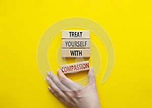 Treat yourself with compassion symbol. Concept words Treat yourself with compassion on wooden blocks. Beautiful yellow background