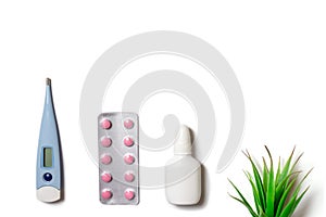 Treatment of cold and flu - various medicines, a thermometer, spray for a stuffy nose and tablets in blister on white background