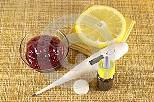 Treatment of colds and flu. Various medications, thermometer, cold pills, throat spray, nasal drops, lemon on a brown background.