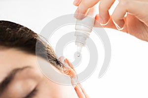 Treatment of ear diseases. A woman buries drops in her ear, close-up.  on a white background. Copy space. The photo