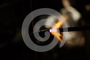 Treatment of molten metal on blurred background, close-up.