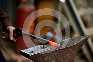 Treatment of molten metal on blurred background, close-up.