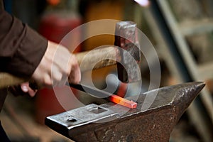 Treatment of molten metal on blurred background, close-up.