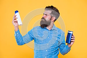 Treatment providing individual care. Hipster hold hair shampoo and conditioner yellow background. Hair treatment