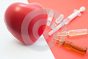 Treatment, support with medication and heart protection. Drugs - vials and syringe on red background aimed at heart, which lies ne
