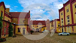 Old reconstructed brewery building with entrance into the storage backyard during nice summer weather