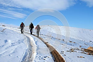 Trecking on snowy path on a sunny winter day photo