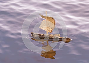 Tree bark boat alone on the sea in sunset.