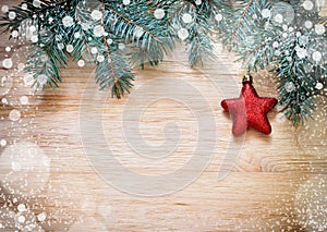 Tree branches with star and snow on wooden board