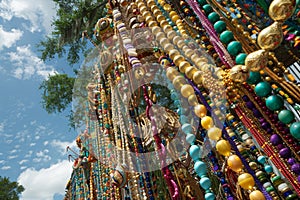 A tree covered in colorful beads and trinkets hanging from its branches, Beads and trinkets cascading from parade floats photo