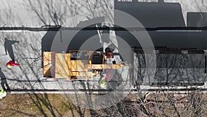 Tree cutting services worker loading cut tree branches into the wood chipper machine for shredding. Top down shot