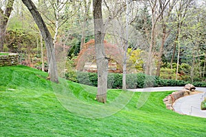 Tree lined pathway with manicured lawn leading to fountain