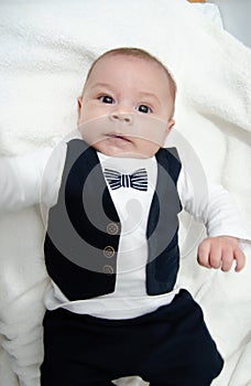 Tree months old newborn baby boy dressed like businessman with bow tie, face expresion