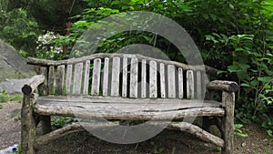 Tree pollen rains down on a New York city hand made wood log park bench like snow in the spring