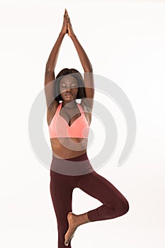 Tree Pose for to find the Balance. Sports african young woman standing in the yoga pose Vrksasana with closed eyes in