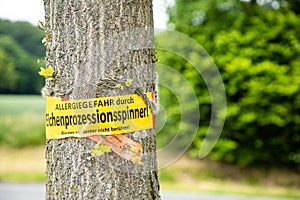 Tree with text vorsicht allergiegefahr durch eichenprozessionsspinner Raupen und Nester nicht berÃÂ¼hren, in englisch beware of photo