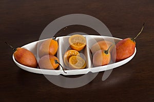 Tree tomato in white ceramic bowl on wooden background