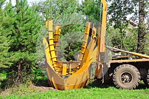 Tree transplanter heavy machine. machine for transplanting large trees. Planting large spruce trees in the park