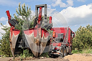 Tree transplanter heavy machine. machine for transplanting large trees. Planting large spruce trees in the park. photo