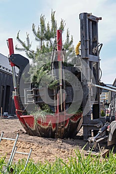Tree transplanter heavy machine. machine for transplanting large trees. Planting large spruce trees in the park. photo