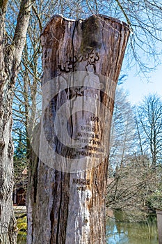 Tree trunk with inscription in German Speak
