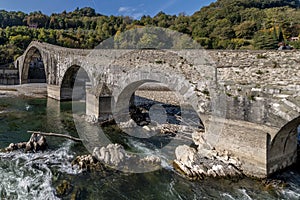 Tree trunks and other debris under the Ponte della Maddalena or del Diavolo bridge, Borgo a Mozzano, Lucca, Italy