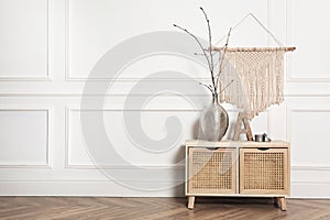 Tree twigs and decor on table near white wall in room. Space for text