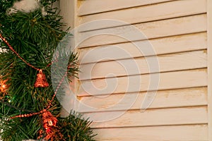 A tree window framed by Christmas tree branches with Christmas decorations.