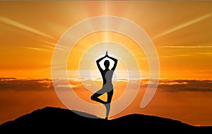 Tree yoga pose, woman silhouette on a cliff meditation at sunset photo