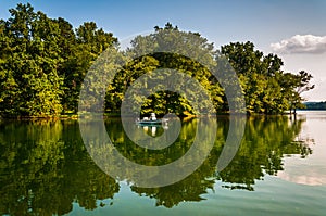 Trees and boat reflecting in Loch Raven Reservoir, near Towson, photo