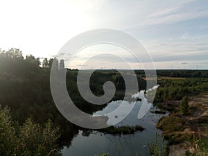 Trees and fields on the sandy shore of the lake. Calm northern latitudes.