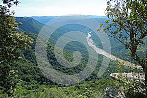 TREES IN FOREGROUND OF RIVER IN ORIBI GORGE CANON