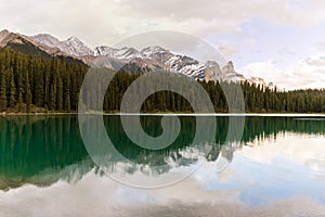 Trees and mountains reflecting on calm lake