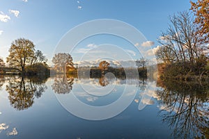 Trees reflected in a flooded meadow after heavy rains. Autumn landscape