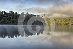 Trees reflected in Lake Kaniere