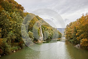 Trees and rock Petushok on riverside of river photo