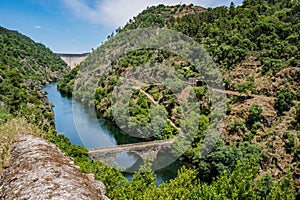 Trees and vegetation on hills in valley with river ZÃÂªzere and Filipina bridge in viewpoint with Cabril dam in the background photo