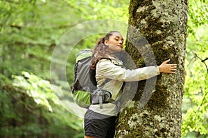 Trekker embracing a tree in a forest