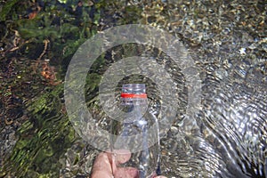 Trekker filling with fresh mountain water from ancient acequia,