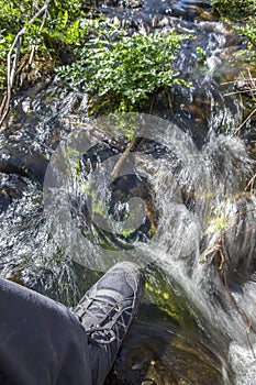 Trekker foot crossing the Muelas river at Cornalvo Natural Park photo