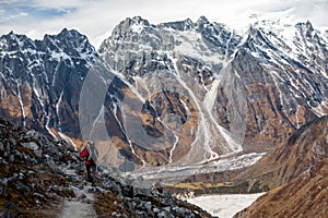 Trekker goes down fron Larke La pass on Manaslu circuit trek in