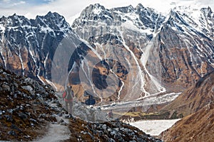 Trekker goes down fron Larke La pass on Manaslu circuit trek in