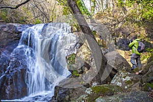 Trekker man taking pictures to Nogaleas waterfall