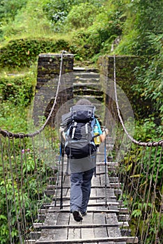 Trekker passing on a suspension bridge