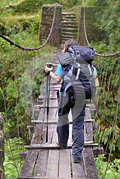 Trekker passing on a suspension bridge