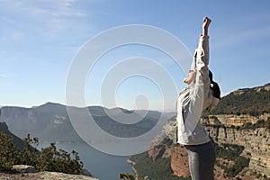 Trekker raising arms celebrating in the mountain