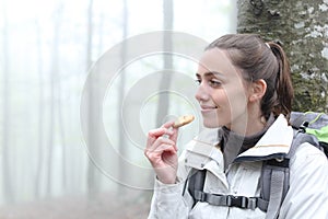 Trekker resting eating cookie in a forest